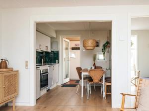 a kitchen and dining room with a table and chairs at 6 person holiday home in Rømø in Sønderby +27 photos