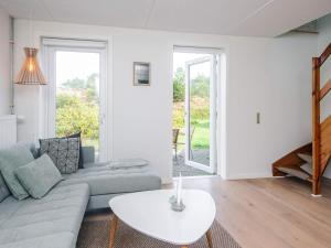 a living room with a couch and a table at 6 person holiday home in Rømø in Sønderby