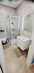 a bathroom with a shower and a sink and a toilet at Marco Polo Apartment in Nazaré