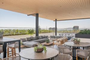a patio with tables and chairs and a couch at Modern Stay in the Heart of Guadalajara in Guadalajara