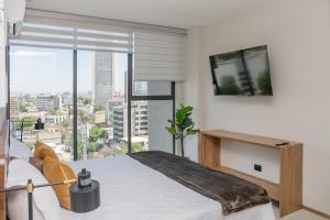a bedroom with a bed and a large window at Modern Stay in the Heart of Guadalajara in Guadalajara