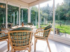 a screened in porch with a table and chairs at Tranquil Retreat in Romo - By Traum Ferienwohnungen in Toftum