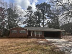 a brick house with a garage in a yard at Newnan Getaway in Newnan