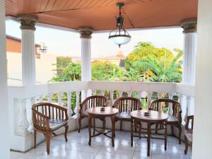 een veranda met een tafel en stoelen en een raam bij Among Rogo Syariah in Yogyakarta