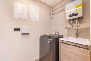 a small kitchen with a sink and a washer and dryer at Jatisa Living by Housy in Medellín +54 photos