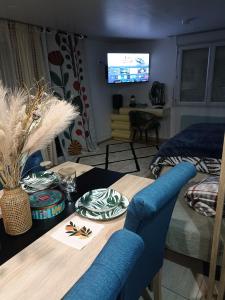 a dining room with a table and a television at L'océane in Saint-Maurice-de-Beynost