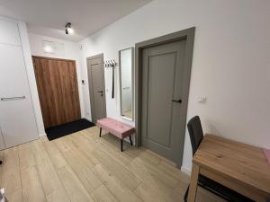 a room with a pink bench and a table at Apartament Brama Pomorza in Chojnice