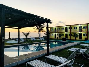 a resort with a swimming pool and lounge chairs at Hotel La Roca Costa Esmeralda in Monte Gordo