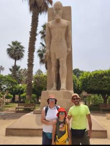 a group of people standing in front of a statue at Inside Pyramids Inn in Banī Ghālib