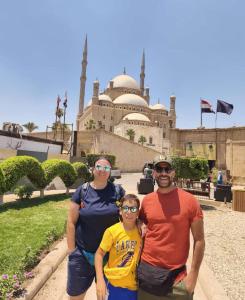 a family posing in front of a mosque at Inside Pyramids Inn in Banī Ghālib +15 photos