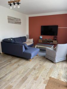 a living room with a blue couch and a tv at brise marine in Le Crotoy
