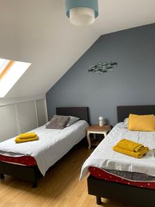 a bedroom with two beds with yellow towels on them at brise marine in Le Crotoy