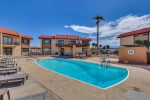 een zwembad in een resort met stoelen en een palmboom bij Less Than 2 Mi to London Bridge Chic Condo with Pool Access in Lake Havasu City