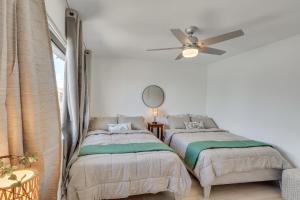 2 bedden in een slaapkamer met een plafondventilator bij Less Than 2 Mi to London Bridge Chic Condo with Pool Access in Lake Havasu City +20 foto's