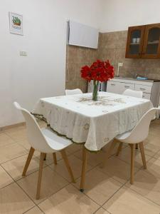 a table with a vase of red flowers on it at Las Peñas in La Rioja