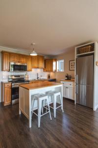 ノースバンクーバーにあるModern Lynn Valley Retreat with Mountain and City Viewsの白いテーブルと冷蔵庫のあるキッチン