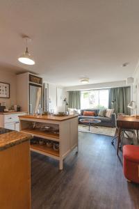 ノースバンクーバーにあるModern Lynn Valley Retreat with Mountain and City Viewsのソファとテーブルのあるキッチンとリビングルーム