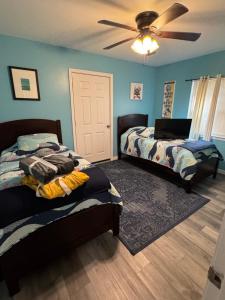 a bedroom with two beds and a ceiling fan at Blue Heron cottage in Gulfport