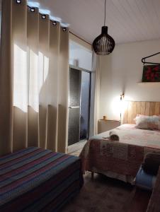 a bedroom with a bed and a large window at Casa Aconchegante in Alto Caparao