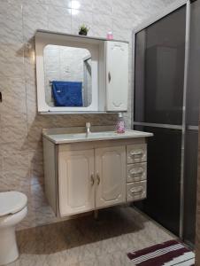 a bathroom with a sink and a mirror and a toilet at Casa Aconchegante in Alto Caparao +22 photos