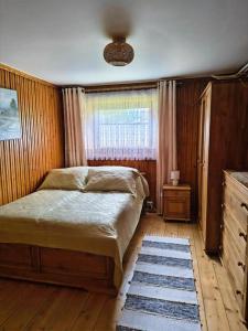 a bedroom with a large bed and a window at Apartamenty u Basi in Leśnica