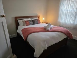 a bedroom with a bed with a stuffed animal on it at Cambridge House, Bendigo in Bendigo