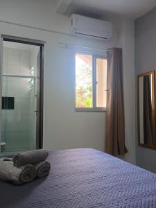 a bedroom with a bed and a window and a shower at Residencial Caramujo in Florianópolis