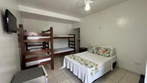 a bedroom with a bed and a bunk bed and a chair at Pousada Suíte Verde Mar in Ubatuba