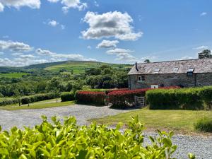 an old stone house with a garden in the foreground at Ysgubor - The Barn in Newchapel