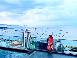 a woman standing on top of a building with a view of the ocean at The Edge Infinity in Pattaya +81 photos