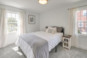 a white bedroom with a bed and two windows at 3 Mi to Dtwn Updated Home with Hot Tub in Lexington in Lexington