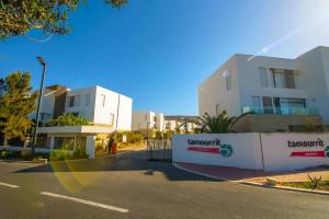 阿加迪尔Taghazout bay resedance tamorret的城市中一条有两栋白色建筑的街道