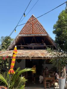 a building with a thatched roof with people sitting on it at Jandaia Atins in Atins