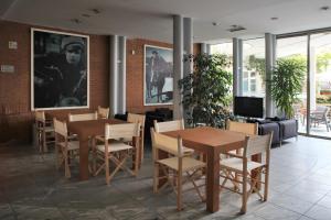 una sala da pranzo con tavoli, sedie e un divano di Hotel Studios a Cologno Monzese