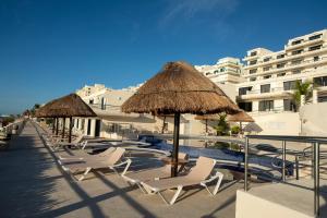 a row of chairs and umbrellas at a resort at HotelZone L20 Beach Access in Cancún