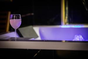 a glass of wine sitting on top of a table at Golden Suite - Elegance - Private Spa Jacuzzi in Lens +11 photos