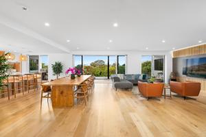 a living room and dining room with a table and chairs at Bombora Beach House in Noosa in Marcus Beach