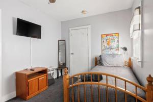 een slaapkamer met een bed, een ladekast en een televisie bij 5 Bedroom House in Tremont, near downtown, and Ohio City Whole in Cleveland