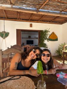 two women sitting at a table with a plant at Jandaia Atins in Atins +73 photos