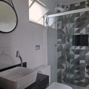 a bathroom with a sink and a toilet and a shower at Residencial Caramujo in Florianópolis +50 photos