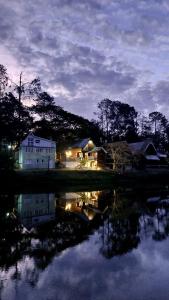 a house and a building next to a body of water at Chale Recanto do Lago in Itu