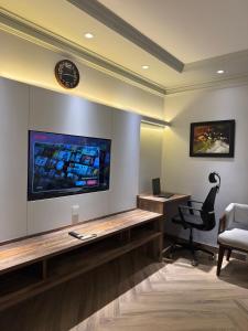 ラホールにあるLe Aura Grand - Luxury Smart Hotel in Lahore by Urban Homesのテレビ、デスク、椅子が備わる客室です。