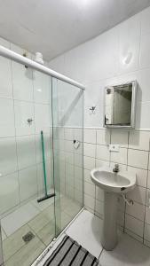 a bathroom with a sink and a glass shower at Pousada Suíte Verde Mar in Ubatuba