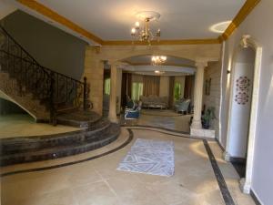 a lobby with a staircase and a living room at The Gardenia Villa Chic Escape with Pool in 6th Of October