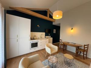 ポール・サン・ペールにあるStudio Jungle avec terrasse et piscine chauffée près de Nantes - FR-1-306-1304のテーブルと椅子のあるキッチンとリビングルーム