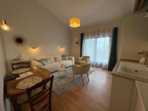 ポール・サン・ペールにあるStudio Jungle avec terrasse et piscine chauffée près de Nantes - FR-1-306-1304のソファとテーブルのあるリビングルーム +6枚の写真