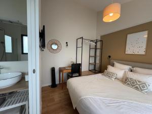 ポール・サン・ペールにあるStudio Jungle avec terrasse et piscine chauffée près de Nantes - FR-1-306-1304のベッドのある寝室と洗面台のある浴室