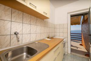 a kitchen with a sink and a view of the ocean at Seaside secluded apartments Cove Torac, Hvar - 589 in Gdinj