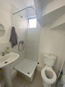 a white bathroom with a toilet and a sink at Casa de 3 habitaciones y 2 baños, Los Andes in Los Andes +11 photos