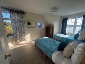 una camera da letto con due letti e una finestra di Acadia Horizon Cottage a Southwest Harbor